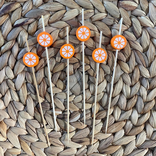 Orange cocktail picks garnishing a spritz